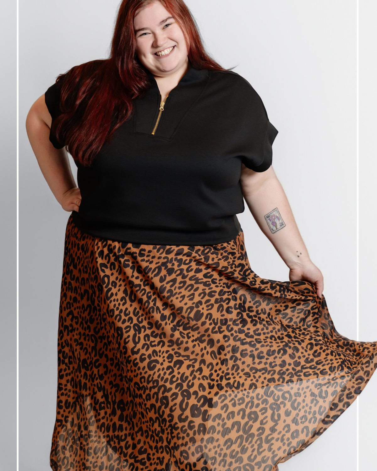 Person wearing a black top and leopard print skirt on a plain background | Model Photo - Cora Jane | Harlow + James Boutique | West Des Moines, IA